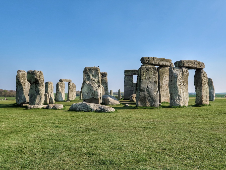 The huge stones of Stonehenge in England with pillars pf rock on top of each other on the grass