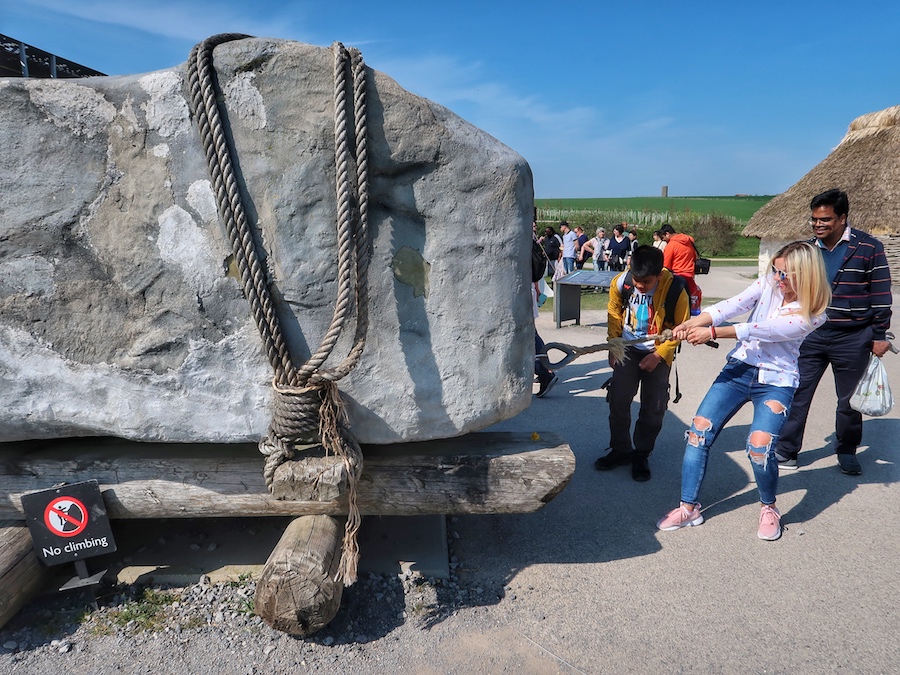 Zuzi is pulling on a rope attached to a replica of a Stonehenge column.